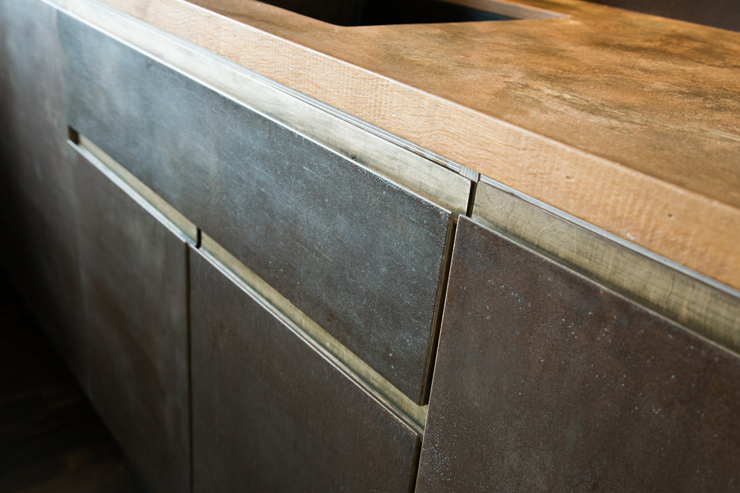 Kitchen drawer fronts made from KAVA Coffee. Used coffee grounds pressed into a birch ply substrate. Pictured, one drawers is marginally open. The handles are made with an added oak lip.